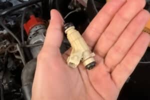 Foto de uma pessoa segurando um bico injetor.