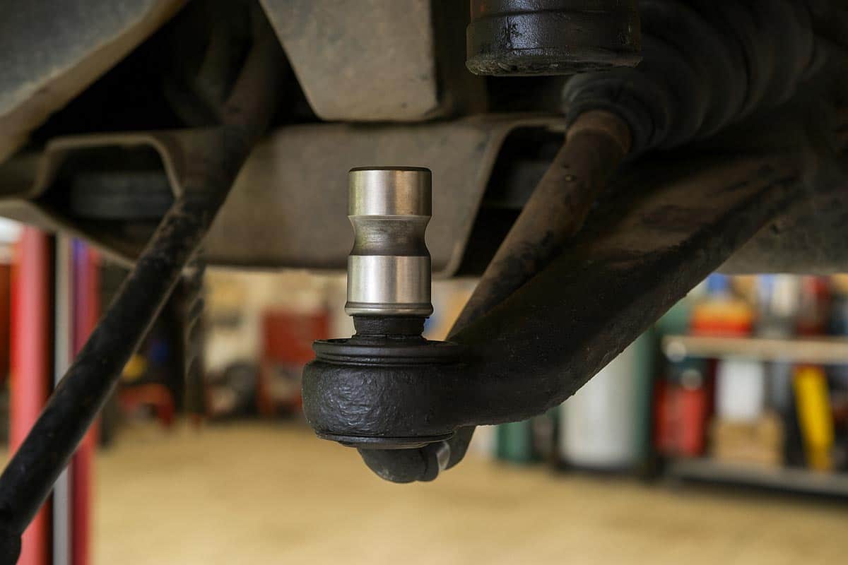 Foto em ângulo fechado mostrando o pivô da suspensão instalado em um carro.