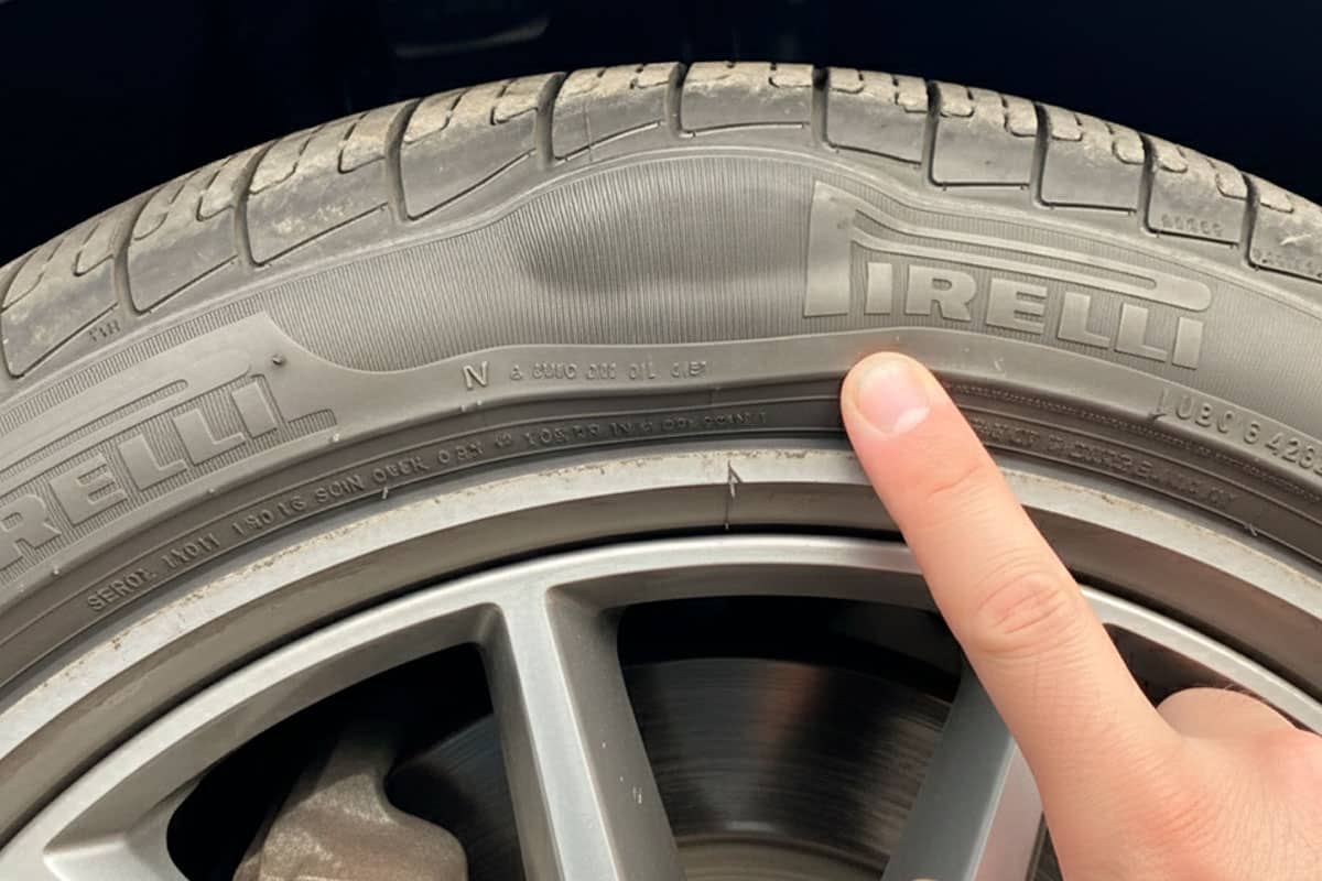 A imagem mostra um pneu Pirelli com uma bolha na lateral.