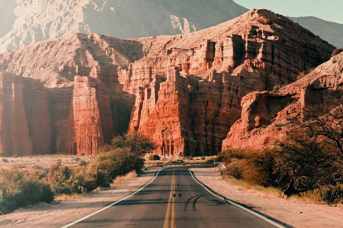 Foto de uma estrada na cidade de Cafayate, Argentina, com uma bela paisagem ao fundo.